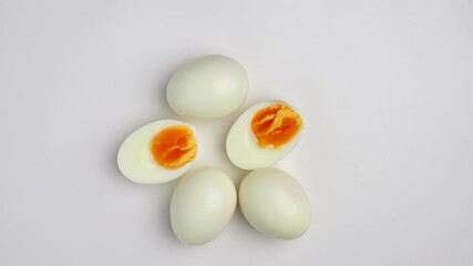 Rotating Top-down shot of a half cut boiled egg on a white background - Powered by Adobe