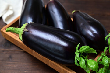 raw whole eggplants in a box on the table close-up
