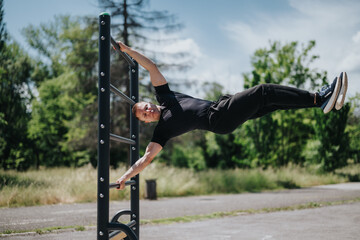 Strong and fit individual demonstrating advanced body control and strength on gym equipment...