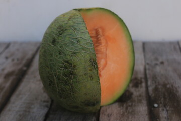 a melon that is cut open so that the orange flesh and many melon seeds are visible