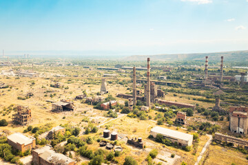 Aerial view derelict industrial zone with overgrown ruins smokestacks and contaminated wasteland in...