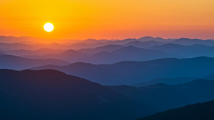 Vibrant sunset paints layers of mountain ranges in warm orange and cool blue hues