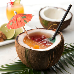 Tropical cocktail in a coconut with straw and umbrella, perfect for summer, beach, and vacation vibes.