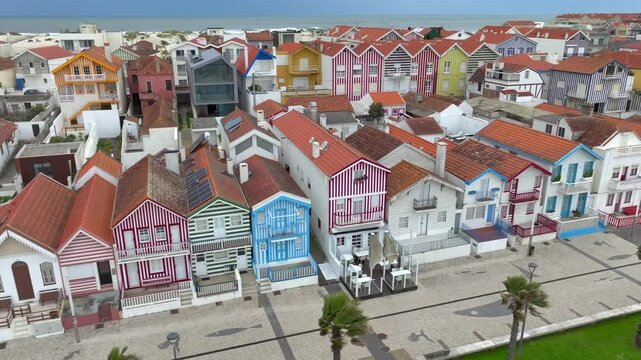Aerial drone sideways panning of colourful houses along Costa Nova do Prado beach, Portugal