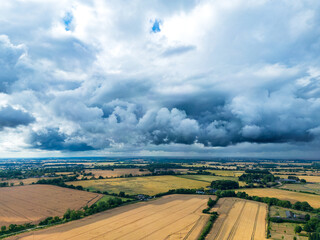 Rolling storm clouds seen gathering over a dry, summer fields in rural Essex, UK. Funnel clouds would shortly form and severe hailstones.