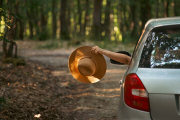 Girl with hat in the window of the car. Adventure, vacation, road trip concept.