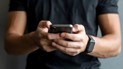 Athletic man interacts with his smartphone while tracking fitness on his smartwatch, showcasing modern connectivity and technological lifestyle with a focus on health and communication.