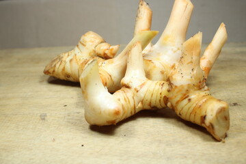 fresh galangal roots with distinct knobby texture arranged on a rustic wooden surface highlighting an essential ingredient in Southeast Asian cuisine
