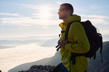 An extreme mountaineer, equipped with professional gear, pushes towards the peak of the mountain at...