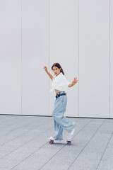 Teen Girl Jumping With Skateboard At Plaza