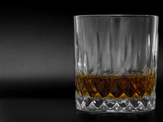 Popular alcoholic drink in a round glass, whiskey without ice in a glass on a black background