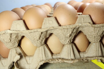 fresh brown chicken eggs perfectly filling in rustic cardboard carton