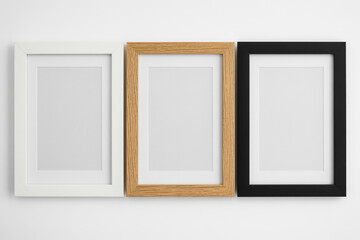 Fototapeta premium Minimalist Picture Frame Set in White, Oak, and Black on White Wall Background (1)