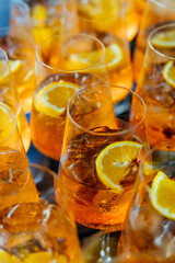 Close-up of multiple Aperol Spritz cocktails garnished with fresh orange slices, creating a vibrant and festive party atmosphere.
