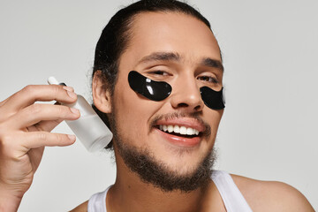 Handsome young man enjoying a self care routine with facial patches and serum