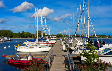 Sailboats and motorboats moored at a tranquil marina.