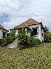 Reis Magos Fort, old white moldy building, stone fortress wall and tiled roof overgrown with grass,...