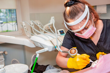 Dentistry. Professional dentist does hardware teeth cleaning with Air Flow for a patient.
