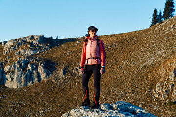 A female mountaineer, equipped with professional gear, enjoys the thrill of her climb as she...