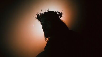Naklejka premium Silhouette of a man with long hair wearing a crown of thorns, representing the Passion of Christ. Religious concept for Easter.