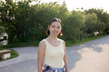 Asian woman in yellow t-shirt smiling. portrait of young Asian woman in park in summer