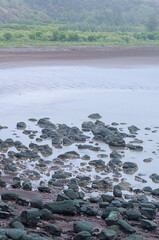 Waves crashing over the beach rocks, rocks and ocean with blurred motion of waves, rocky shoreline meeting coastal waters