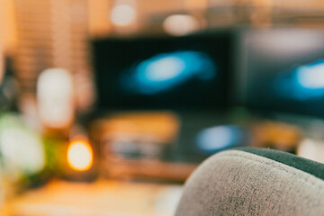 Modern cinematic desk setup with triple monitor, gaming chair, ambient light, and cozy atmosphere for work or gaming.