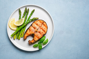 Grilled salmon steak with green asparagus and lemon slices