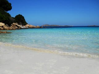 A beautiful beach view that captures the essence of paradise soft golden sands stretch along the shoreline, kissed by gentle waves of crystal-clear, turquoise water. The sun glistens on the surface of