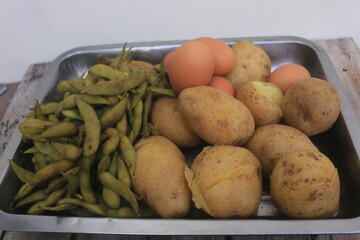 Edamame, eggs and potatoes that have been boiled are placed in one container and will be processed...