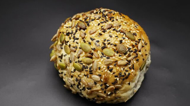 Rotating Close-up shot of soft, golden brown multigrain bread on black background