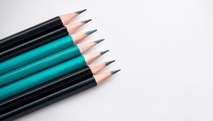 Naklejka premium black and teal pencils on white background