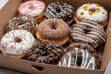 Assorted donuts in a bakery box, close-up vibrant food photography with colorful toppings and studio lighting