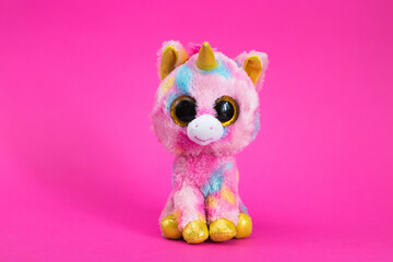 Toy cartoon koala sits on a white gift box on a pink background