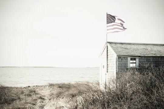 Seaside shed with American flag, black and white
