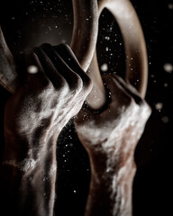 Male Gymnast Gripping Chalked Wooden Rings