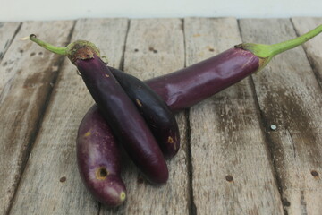 The purple eggplant placed on the table looks wilted