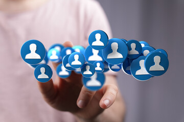 Image of a hand interacting with digital profile icons, representing social media, networking, and...