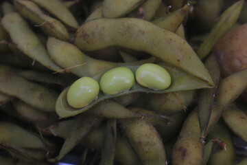 Boiled edamame is placed in a container and will be processed into a fruit salad.