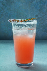 Salty Dog cocktail with fresh grapefruit juice, lime juice, and thyme, in a Collins glass with ice,...