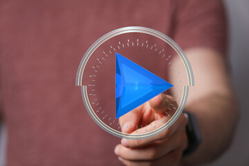 Hand interacts with a futuristic play button, symbolizing digital media, technology, and user...