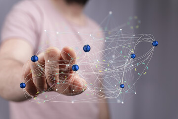 Person's hand interacts with a complex network of digital nodes. Represents connection, technology,...