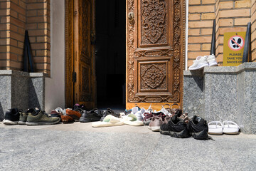 There is a warning to take off your shoes at the entrance of the mosque and many shoes are placed in front of the door, Samarkand, Uzbekistan