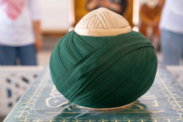 Traditional green turban placed on a tomb of Imam al Matrudiy, the turban carefully wrapped with green fabric. Samarkand, Uzbekistan