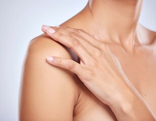 Woman's hand on bare shoulder, showcasing smooth, healthy skin, body care, and tactile comfort.