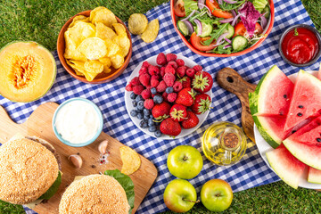 Summer picnic or BBQ brunch or lunch background, tasty barbecue table with hamburgers, salads,...