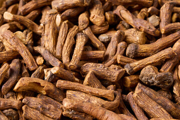 closeup pile of dry dandelion root herb for loose tea background texture