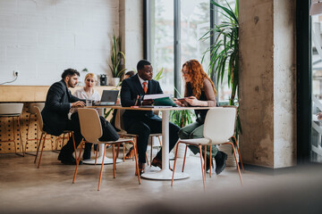 A group of people collaborating and discussing ideas in an urban co working space. The setting...