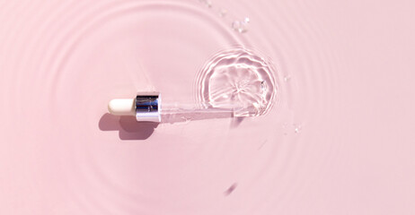 pipette serum in water on pink background ripples water drops natural sunlight