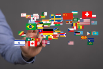 Image of a hand interacting with a digital display of various world flags, symbolizing global...